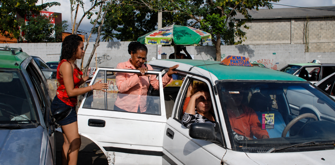 Momentos en que pasajeros abordan un carro público en El Gran Santo Domingo.