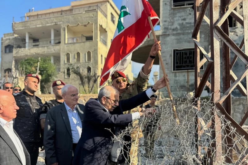 El primer ministro de Líbano, Nawaf Salam, al centro, iza una bandera libanesa durante una visita al pueblo sureño Zawtar Al Gharbieh en Líbano