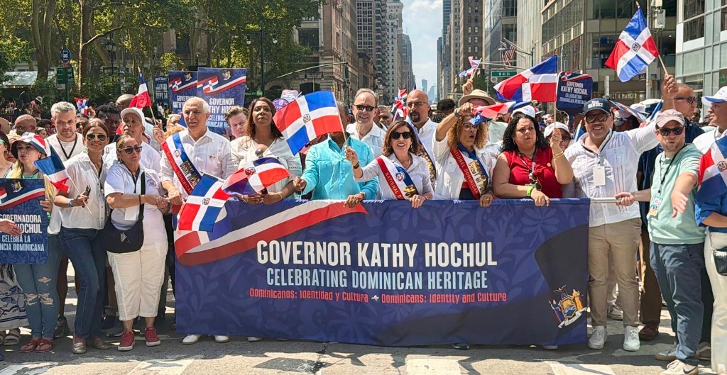 El doctor Ramón Tallaj, junto a Kathy Hochul, gobernadora de Nueva York, y otras autoridades municipales, camina a todo lo ancho de la Sexta Avenida durante el Desfile Nacional Dominicano.