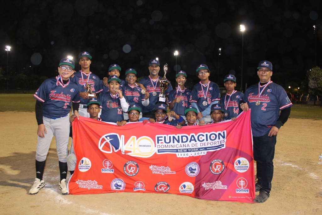 Los integrantes de la categoría 11-12 años de Van Cortlandt Baseball League posan felices con sus medallas de oro y la copa de campeones, orgullosos de la conquista alcanzada en los Juegos de la Comunidad 2026.